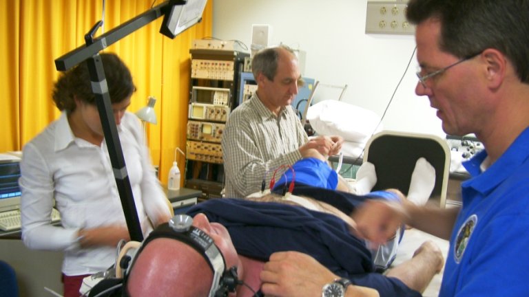 André Kuipers ligt met hoofdband als proefpersoon op de kieptafel in de aanloop naar de Delta-vlucht naar het International Space Station (2004).   